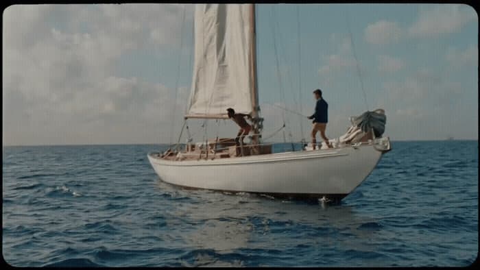 a couple of people on a sailboat in the water