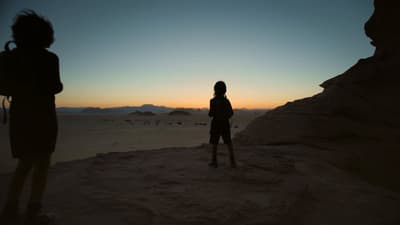 a couple of people that are standing in the sand