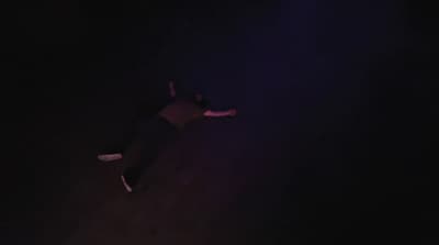 a person laying on the ground in the dark