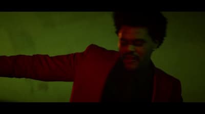 a man in a red jacket is holding his arms out
