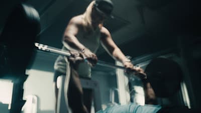 a man holding a bar in a gym