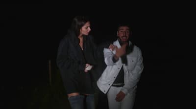 a man standing next to a woman in the dark