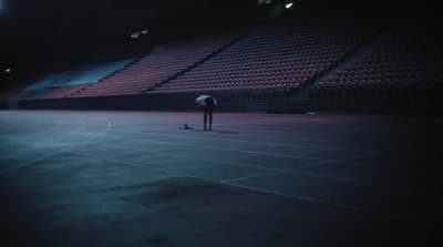 a person standing on a tennis court with a racquet