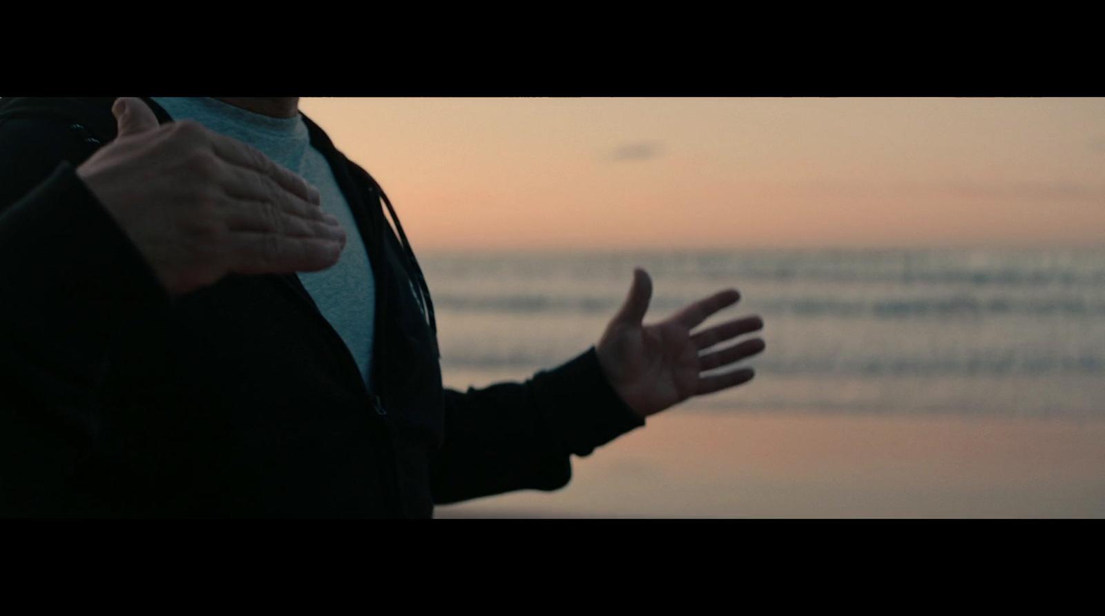 a person with their hands out in front of a body of water