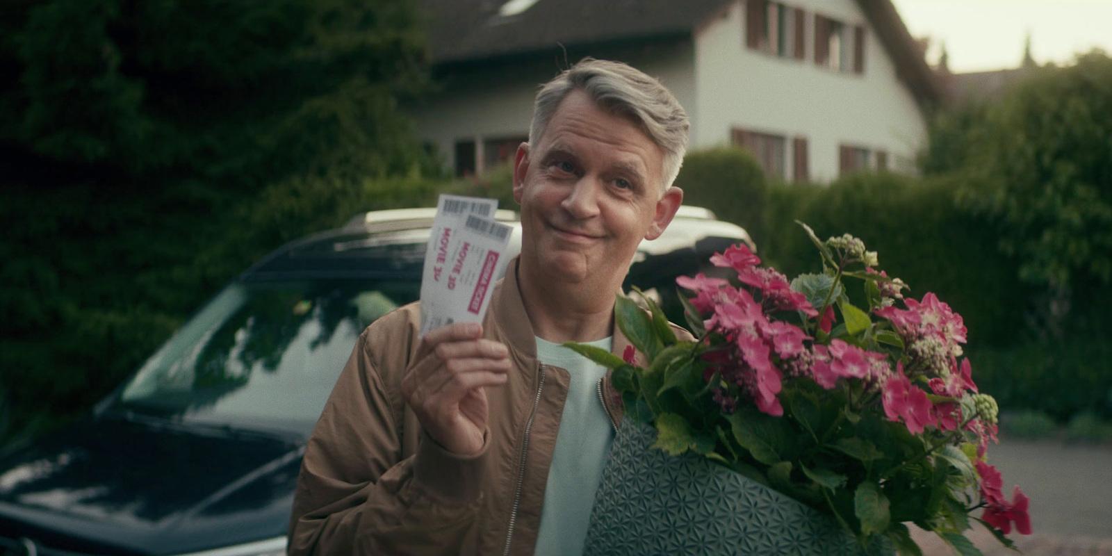 a man holding a piece of paper next to a car