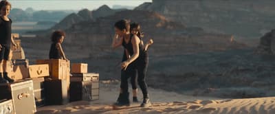a group of people standing on top of a desert