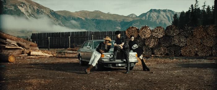 a group of people standing next to a car