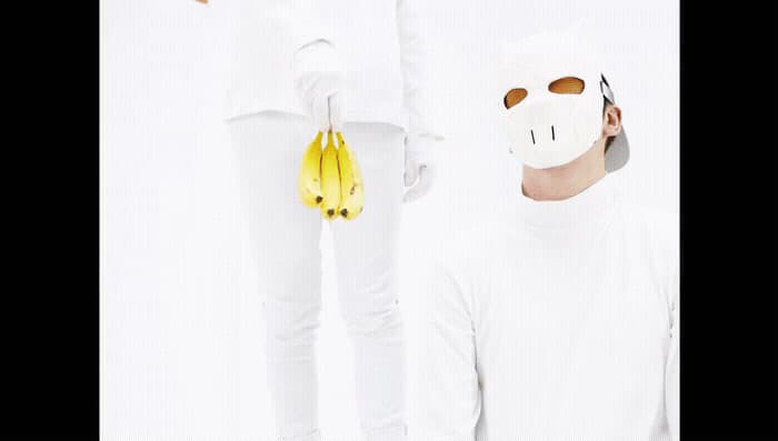 a man wearing a mask and holding a bunch of bananas