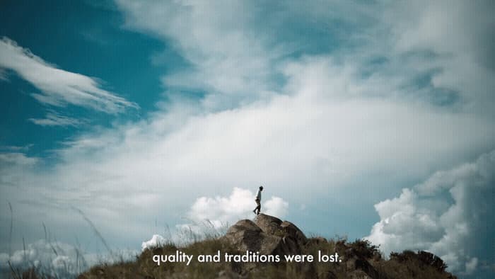 a person standing on top of a hill with a sky background