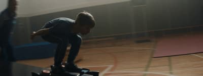 a young boy riding a skateboard on top of a wooden floor