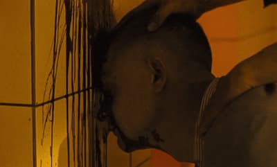 a man standing next to a wall with a knife in his mouth