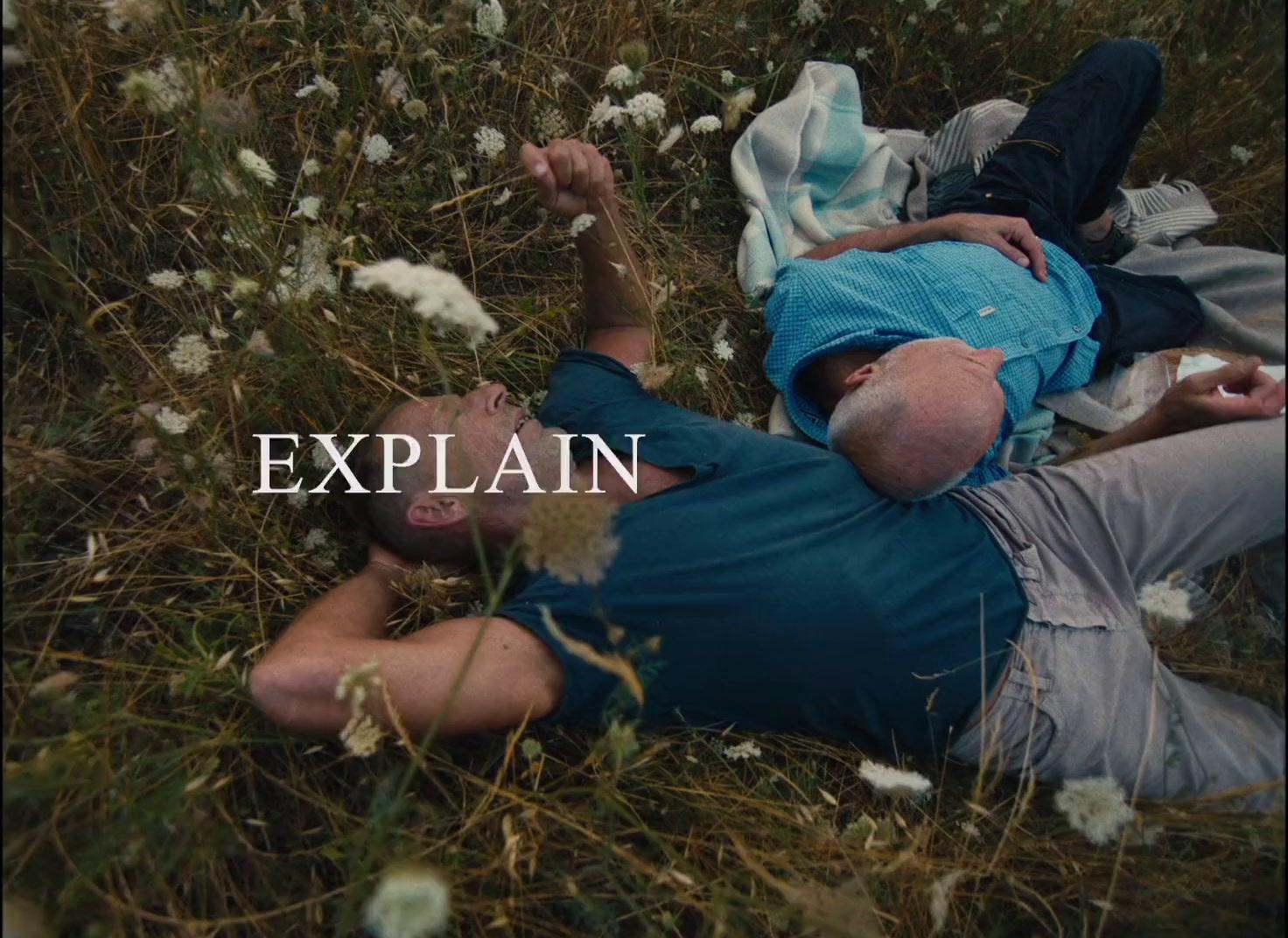 a man laying on top of a grass covered field