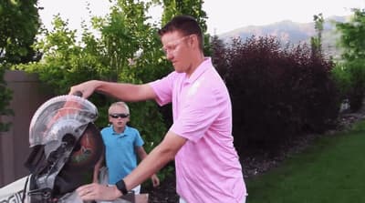 a man in a pink shirt putting something in a cooler