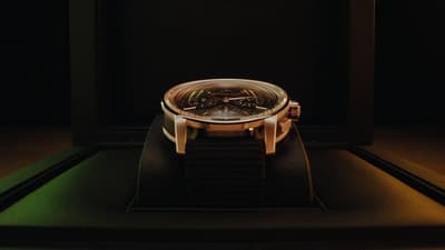 a watch sitting on top of a black surface