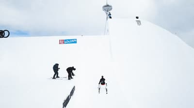 a group of people riding skis down a snow covered slope