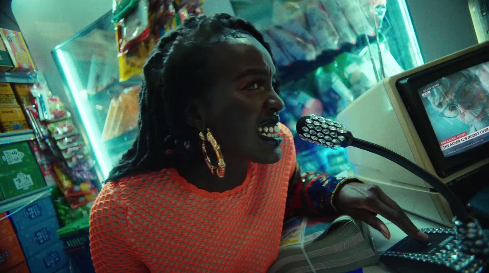 a woman with a microphone in front of a computer