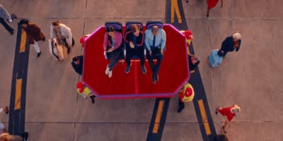 a group of people sitting on top of a red bench