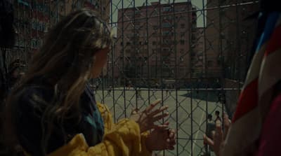 a woman standing in front of a fence with her hands out