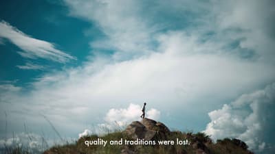 a person standing on top of a hill with a sky background