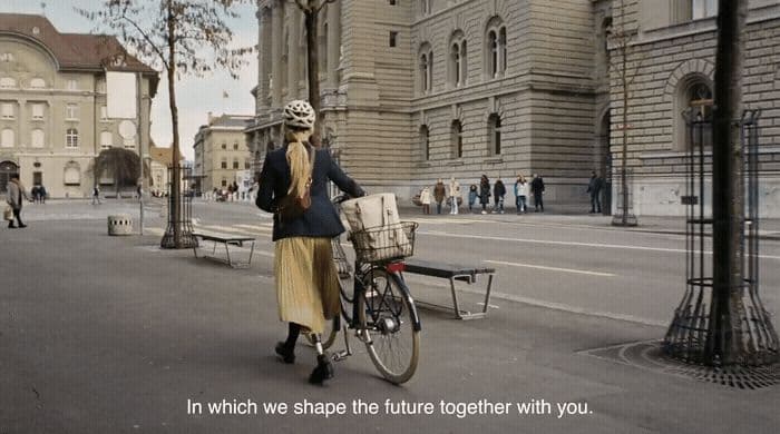 a woman is walking her bike down the street