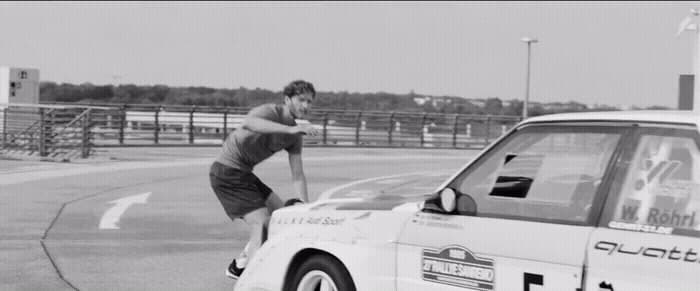 a man riding a skateboard next to a parked car