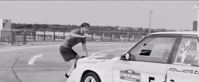 a man riding a skateboard next to a parked car