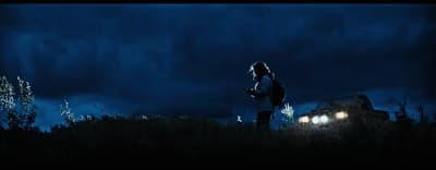 a person standing in a field at night