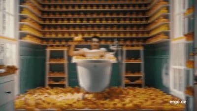 a man sitting on a toilet in a room filled with oranges