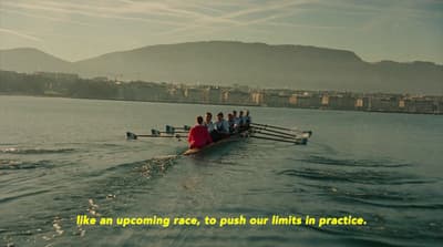 a group of people rowing a boat in the water