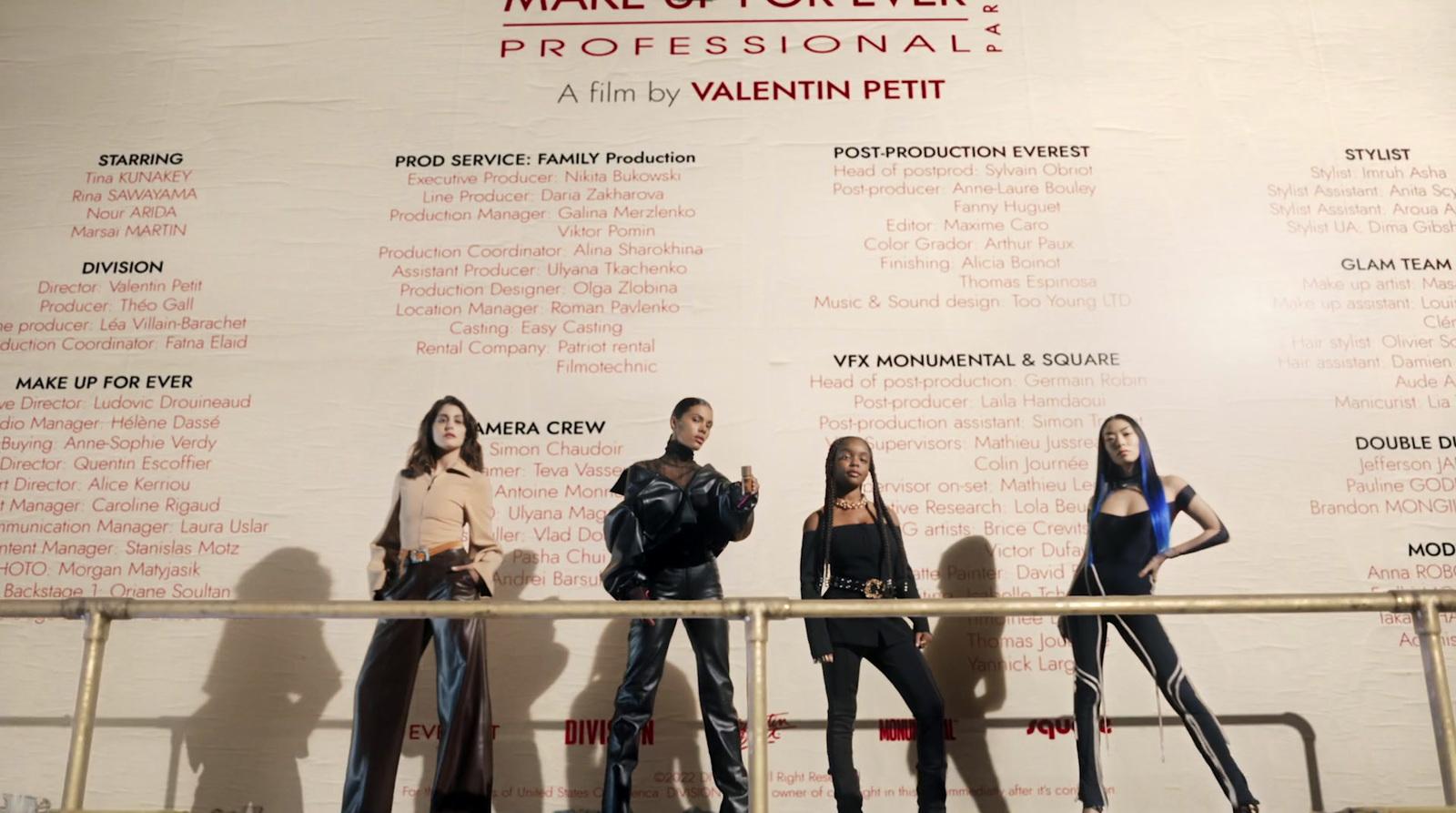a group of women standing next to each other in front of a wall
