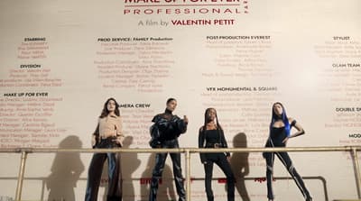 a group of women standing next to each other in front of a wall