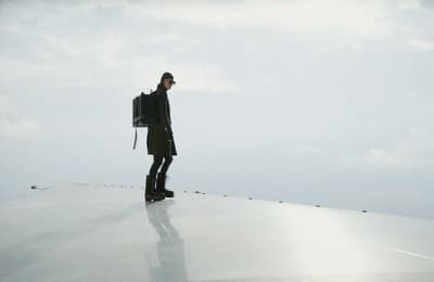 a man standing on top of a roof with a backpack