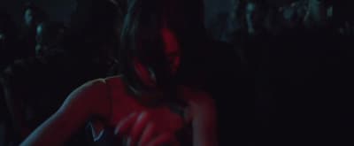 a woman in a red dress standing in a dark room