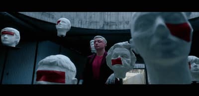 a man standing in front of a group of fake heads