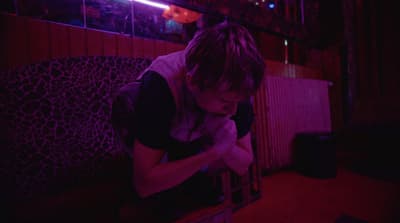 a person sitting on a bench in a dark room