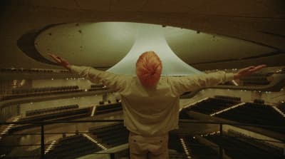 a person standing in front of a large light fixture