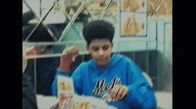 a young man sitting at a table eating food