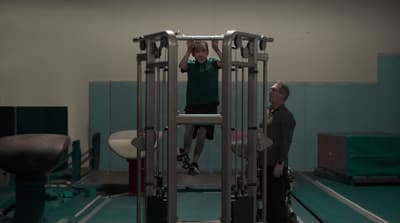 a man standing on a machine in a gym