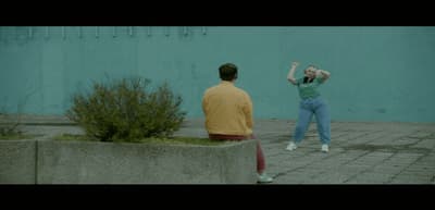 a man standing next to a woman on a sidewalk