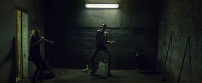 a man and a woman standing in a dark room