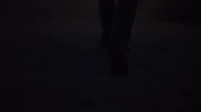 a person standing in the dark holding a cell phone