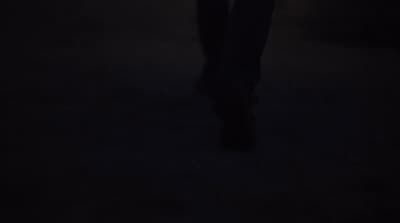 a person standing in the dark holding a cell phone