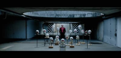 a man standing in front of a bunch of fake heads
