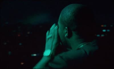 a man with his hands on his face in the dark