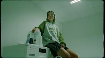 a woman sitting on top of a washing machine