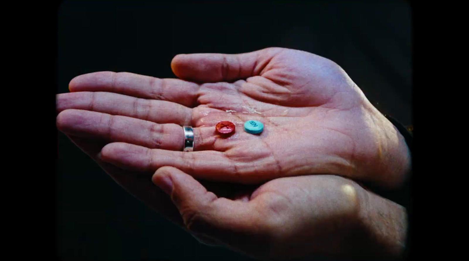 a person's hand holding three different colored beads