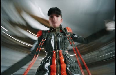 a woman in a black and red dress is dancing