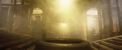 a man standing in front of a light in a factory