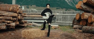 a woman in a black dress holding a white guitar