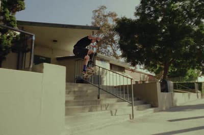 a man riding a skateboard down the side of a set of stairs